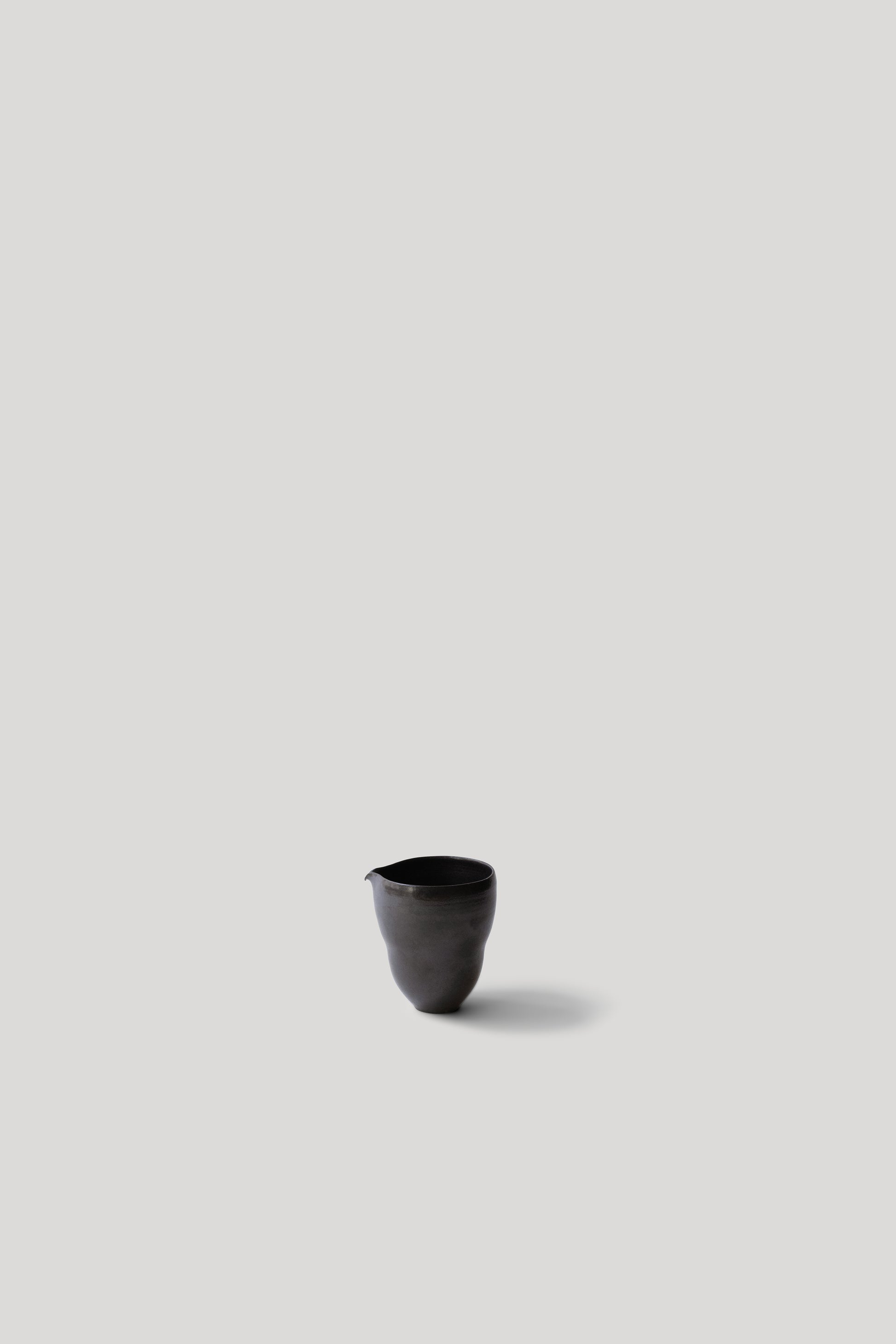 Black ceramic cup on a light gray background