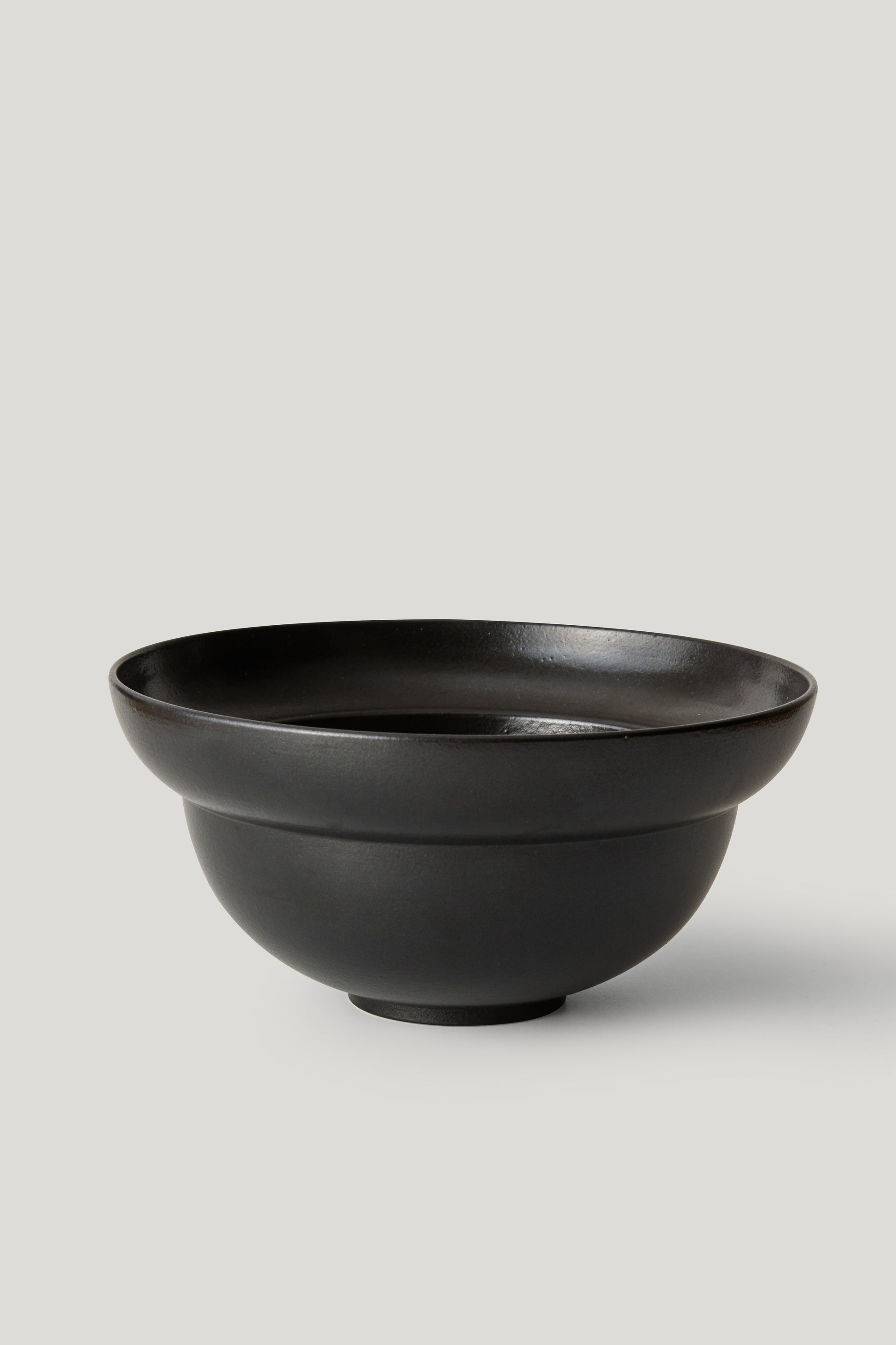 Black ceramic bowl on a light gray background