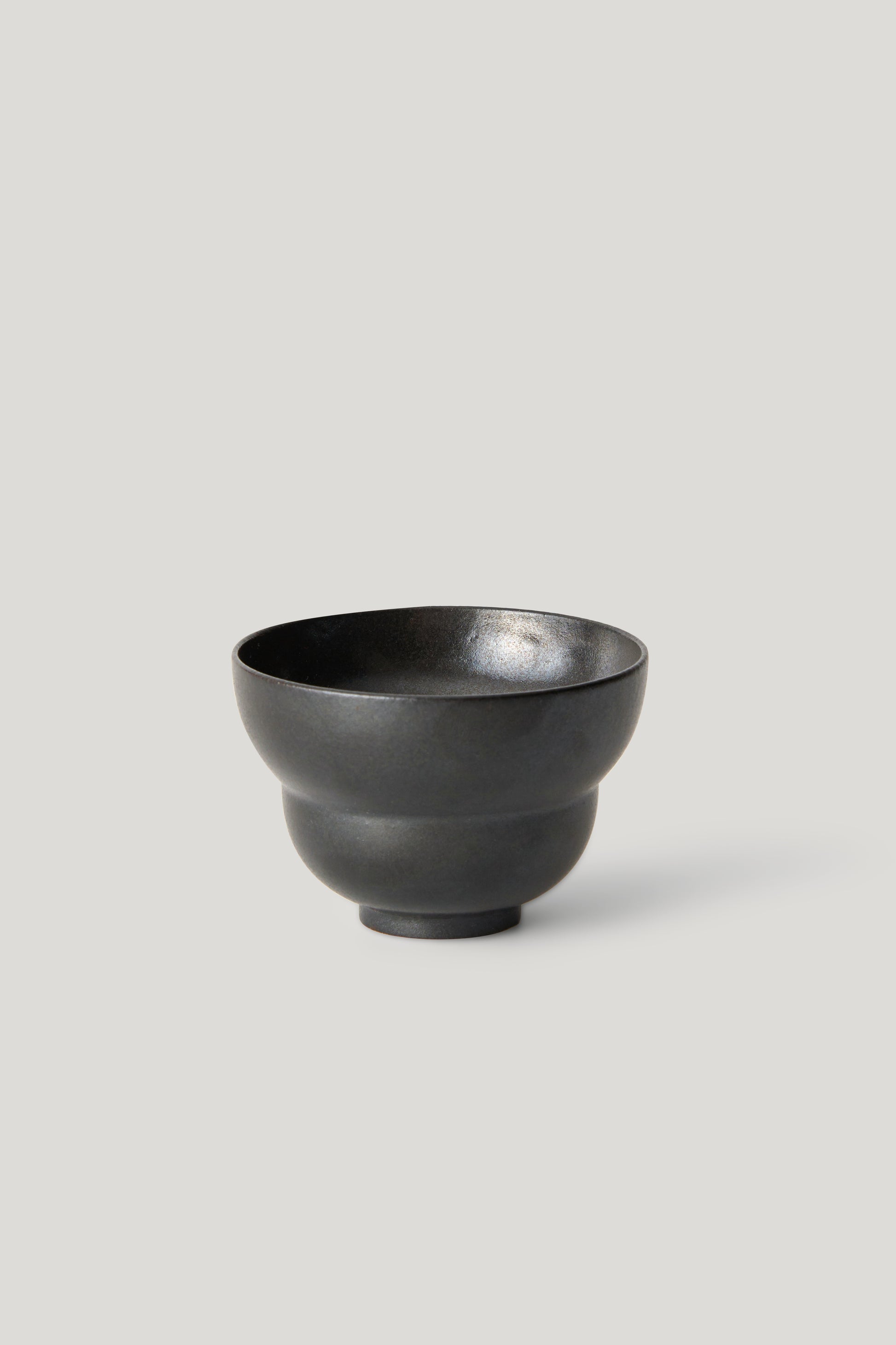 Black ceramic bowl on a light gray background