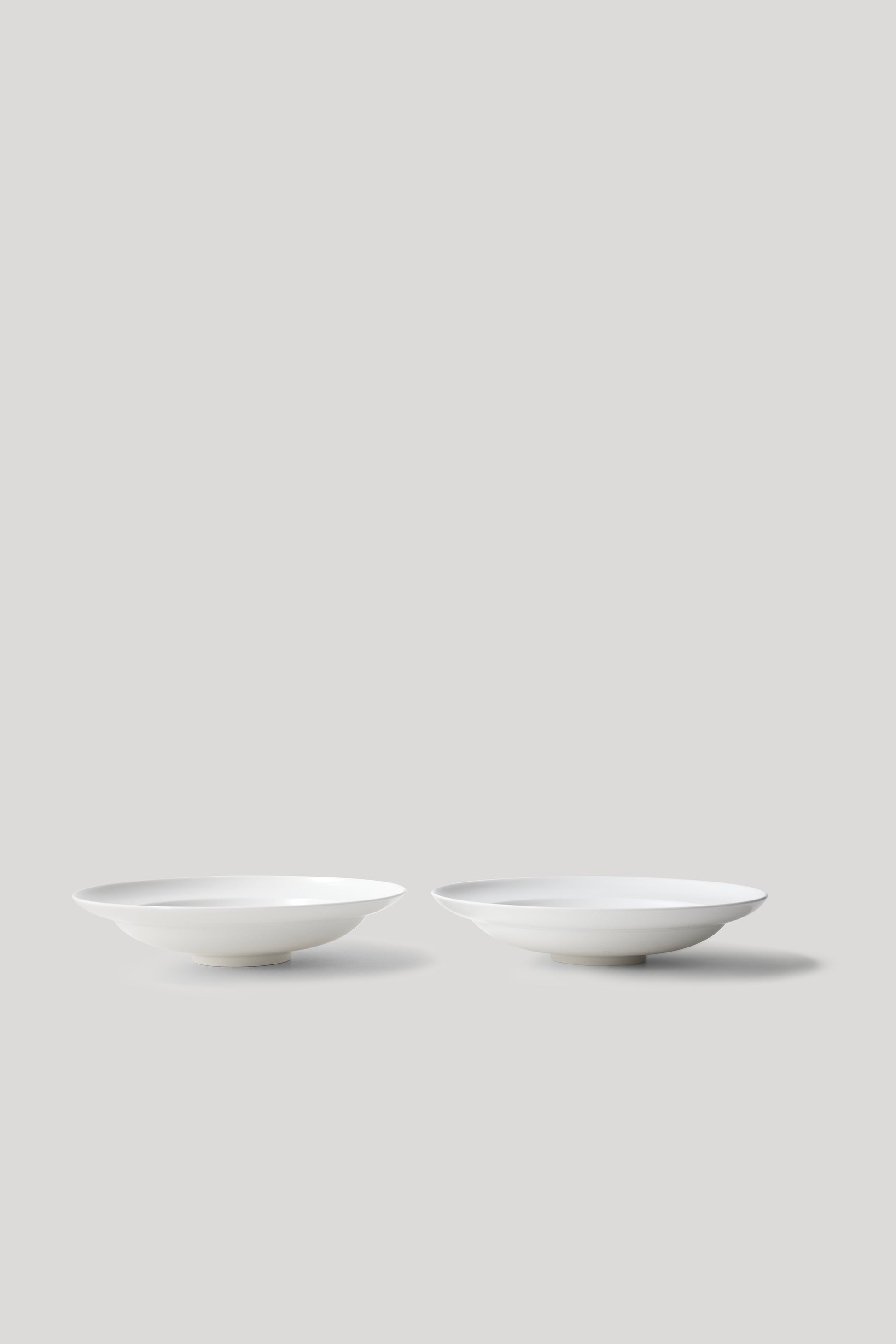 Two white ceramic bowls on a light gray background