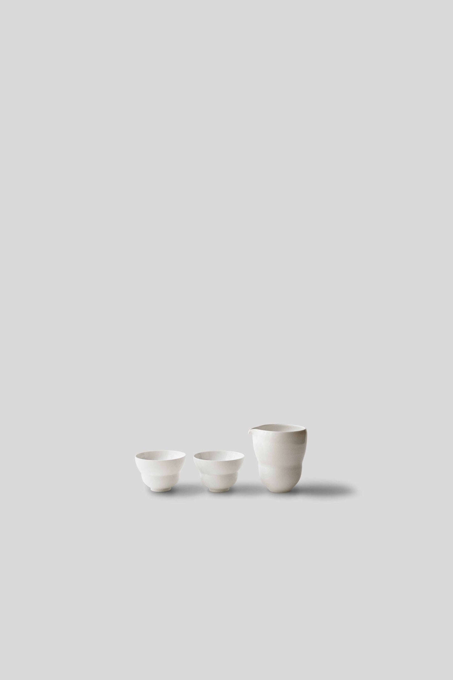 Three small white ceramic bowls on a light gray background