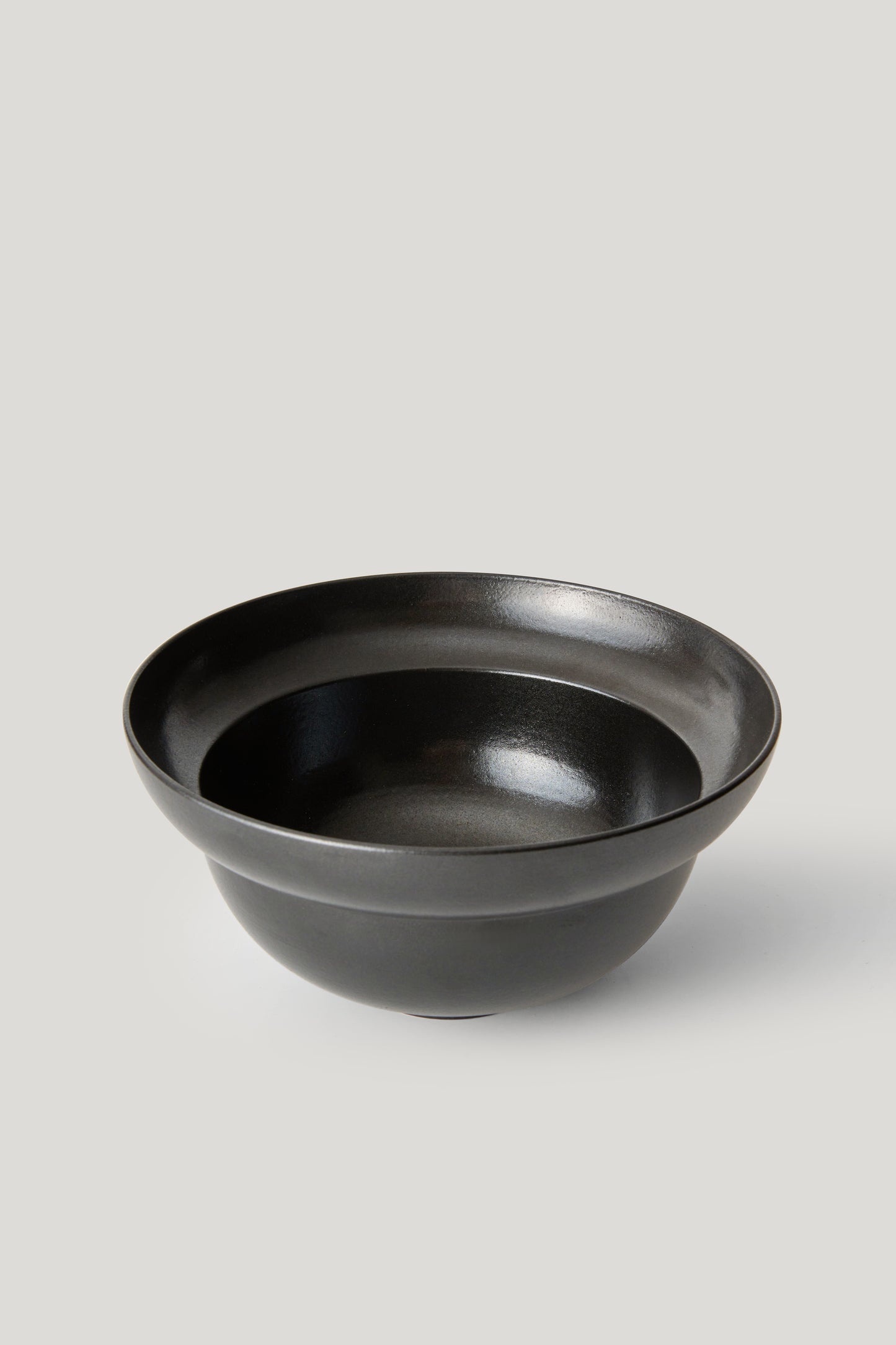 Black ceramic bowl on a light gray background