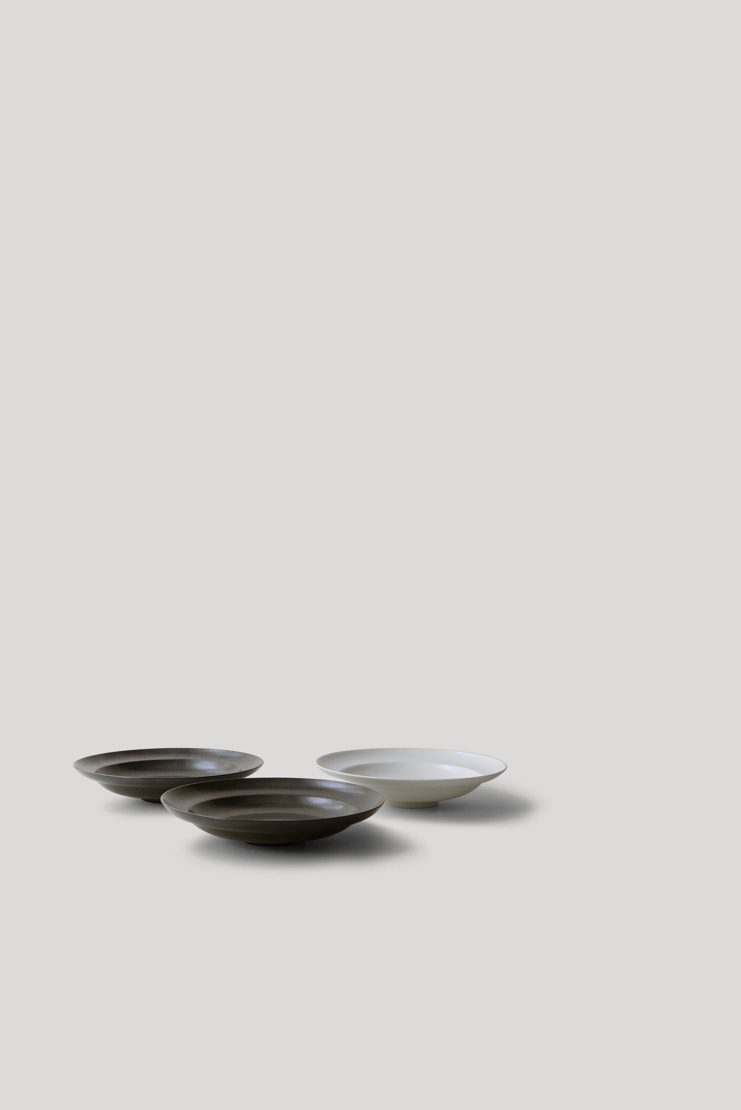 Three ceramic bowls in black and white on a light gray background