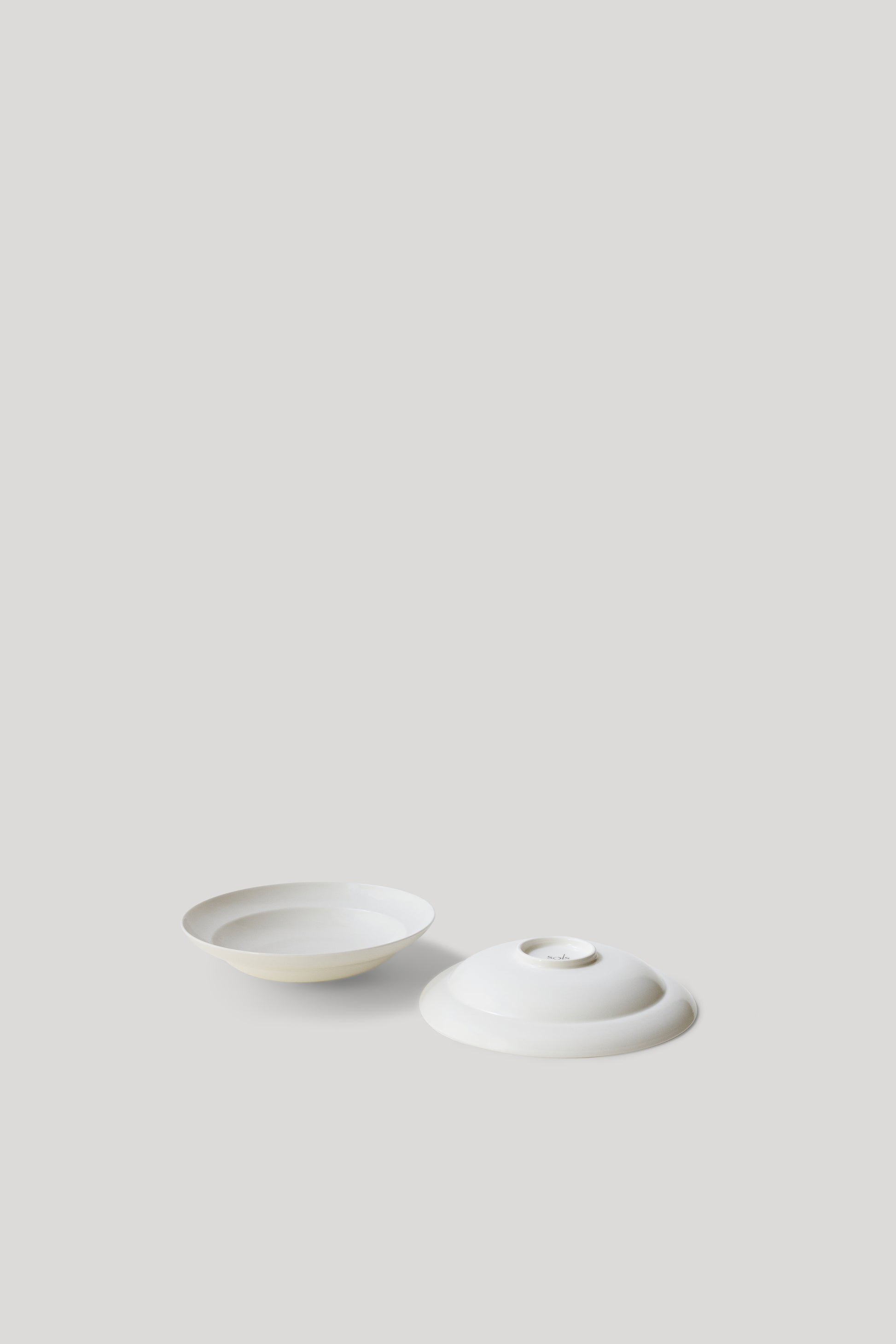 Two white ceramic items on a light gray background