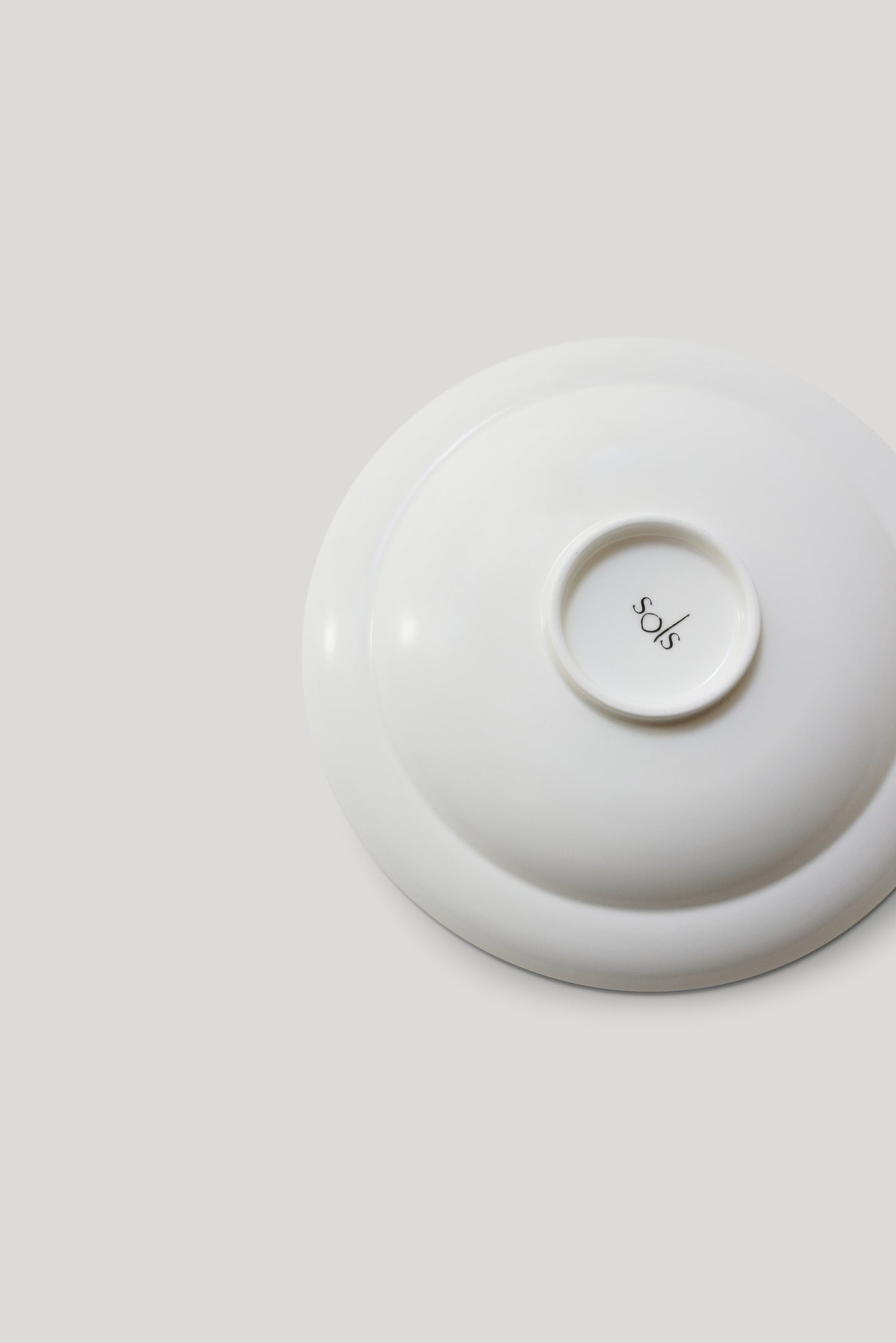 White ceramic dish with a lid on a light gray background