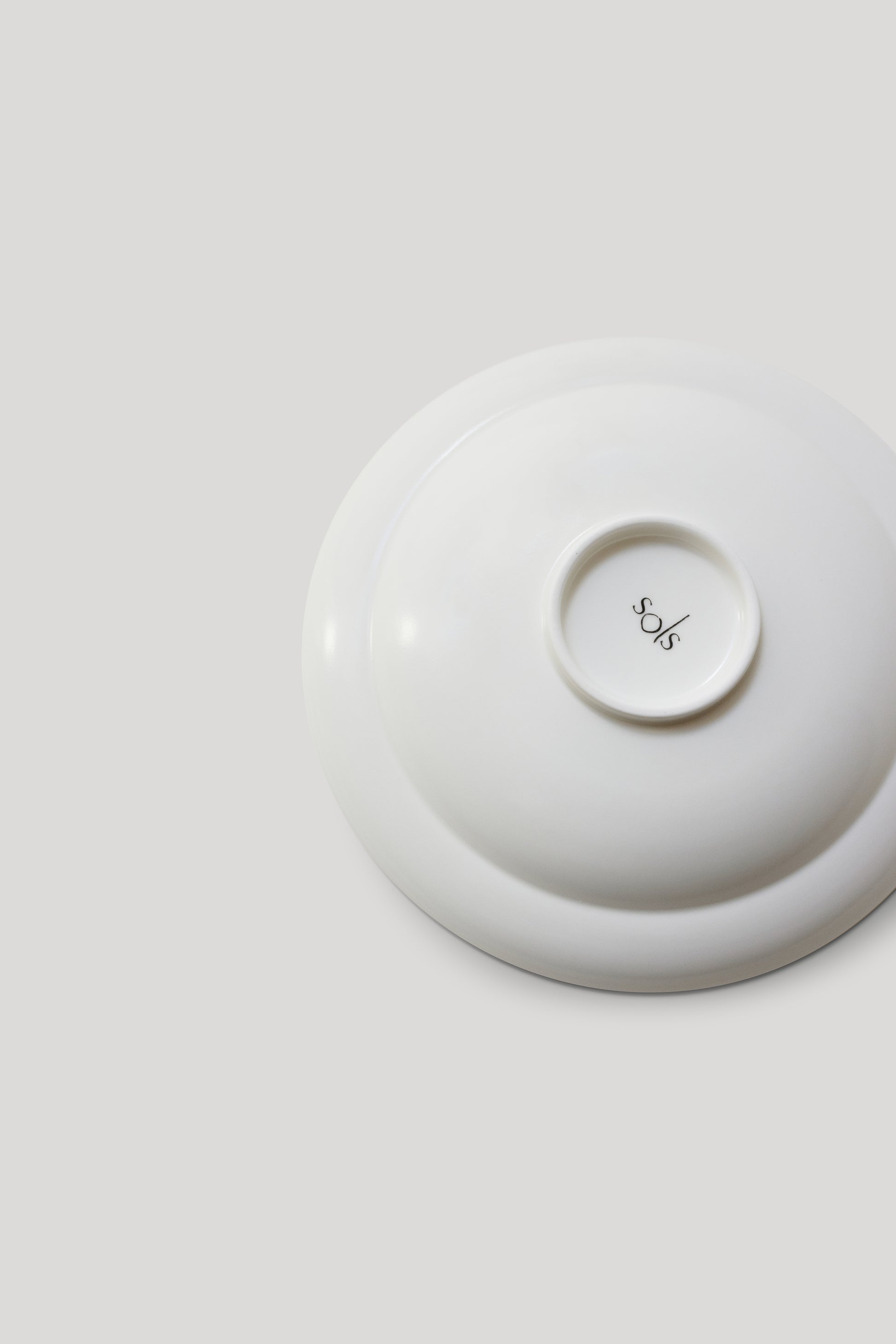 White ceramic dish with a lid on a light gray background
