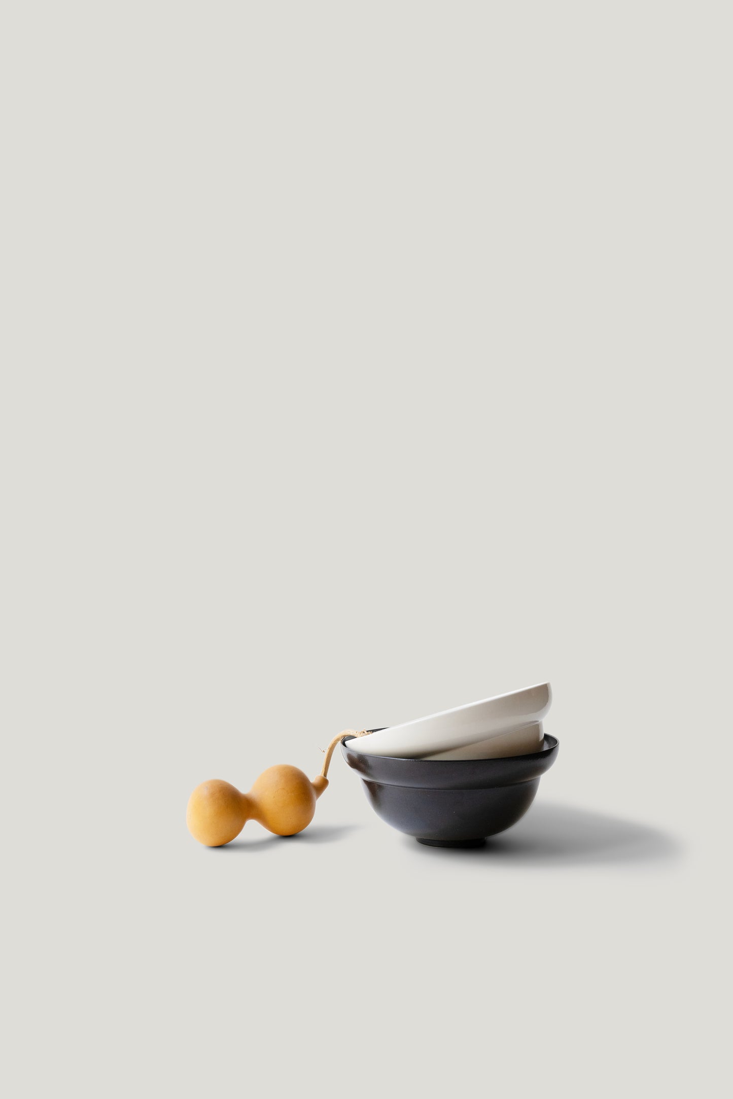 Small black bowl with a yellow handle on a light gray background