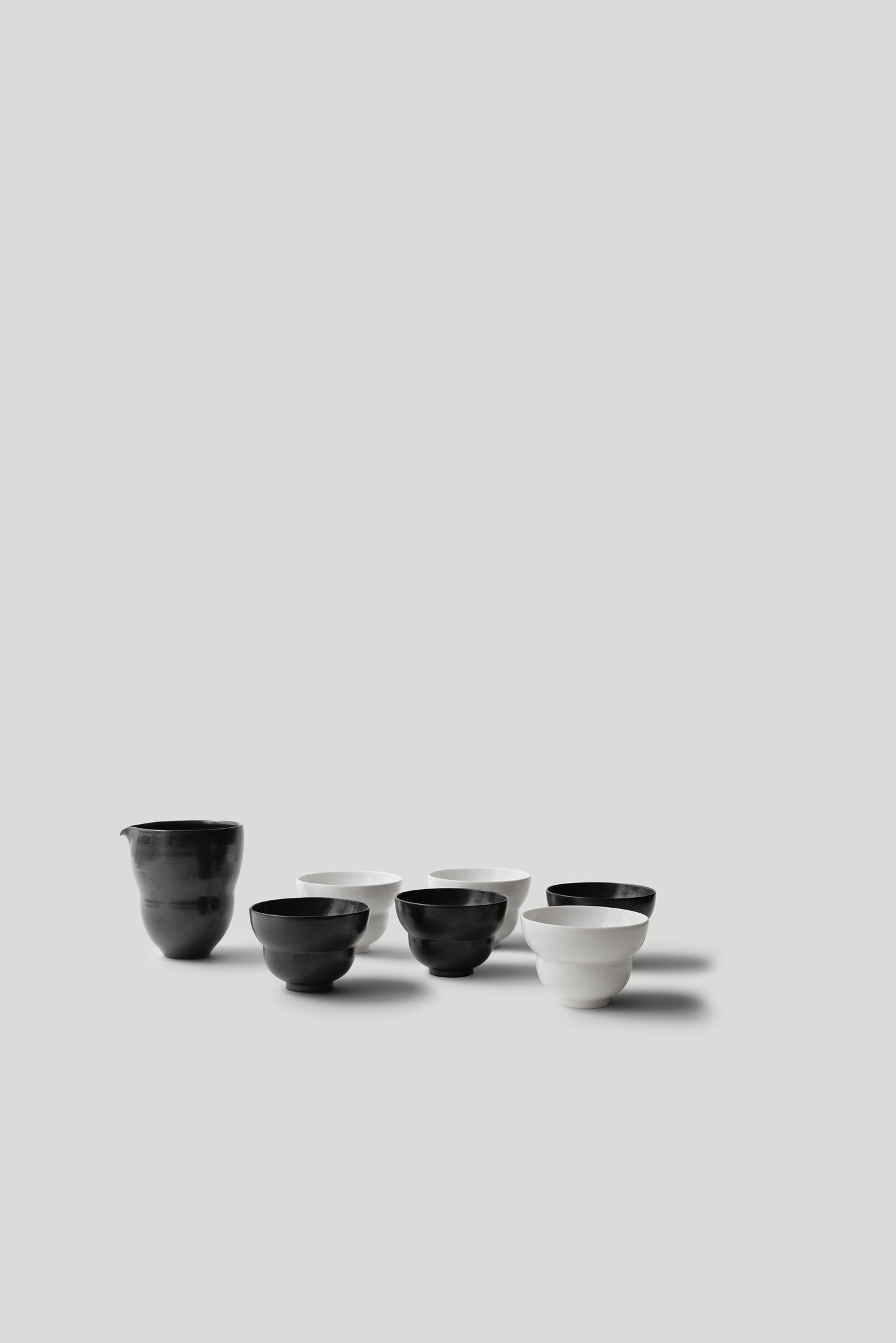 Set of black and white ceramic bowls on a light gray background