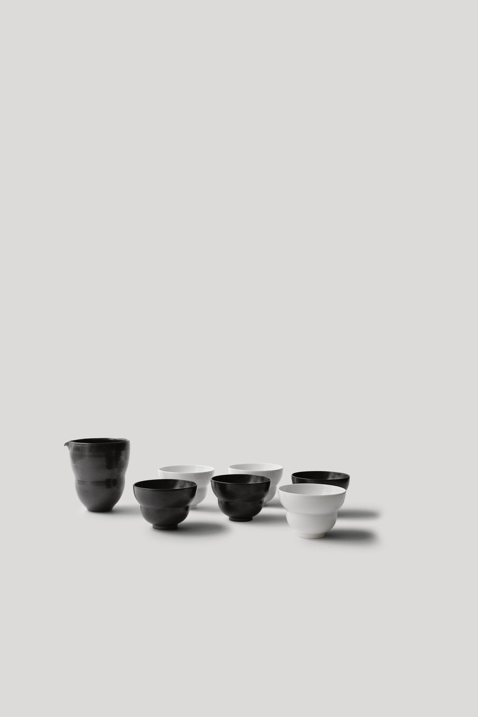Set of black and white ceramic bowls on a light gray background