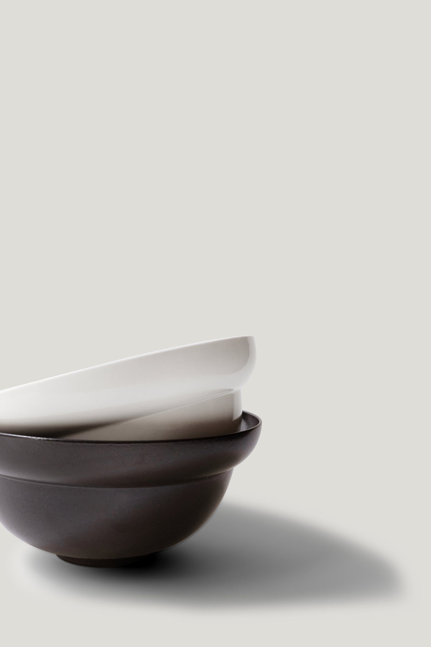 Two ceramic bowls stacked on a light gray background