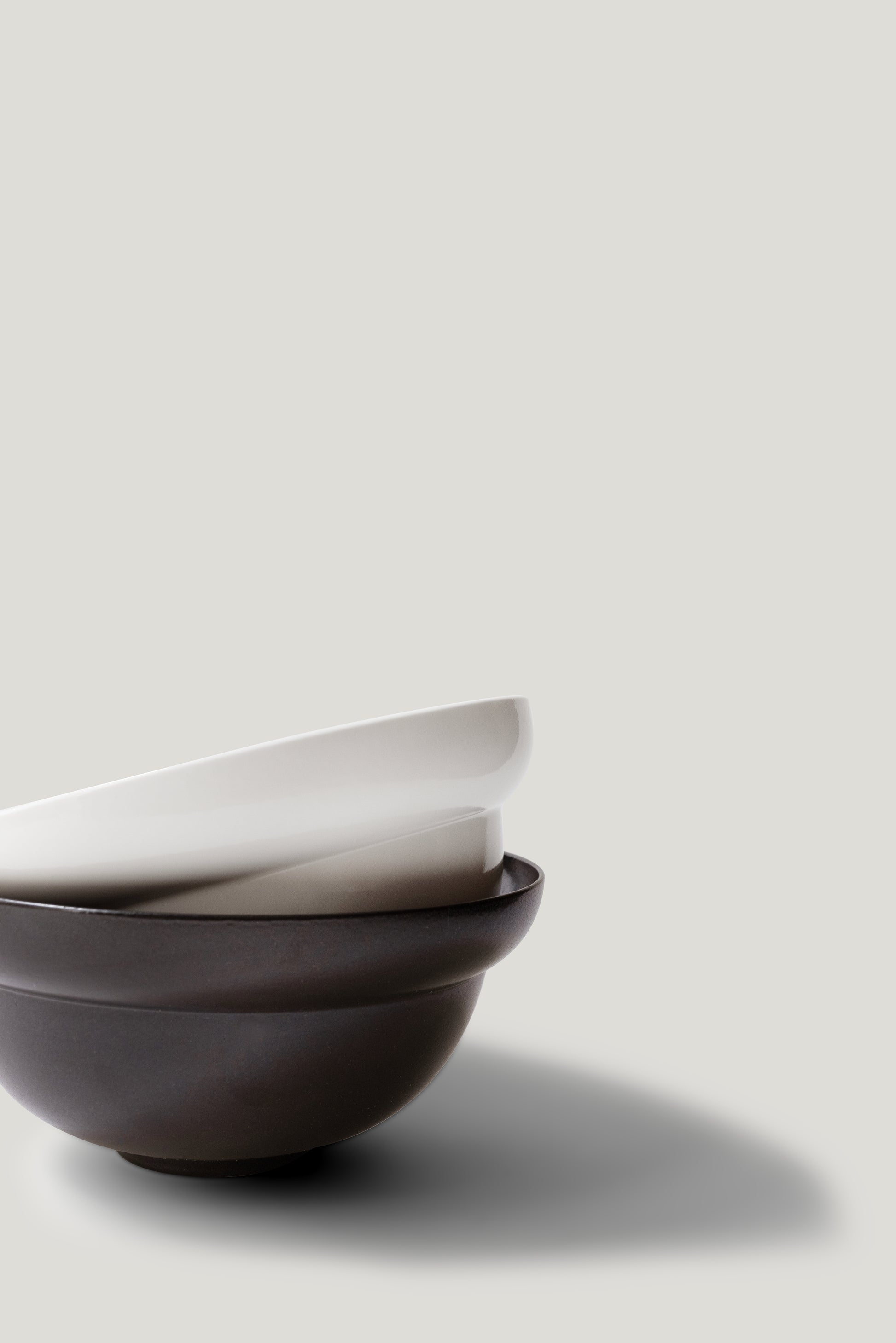 Two ceramic bowls stacked on a light gray background