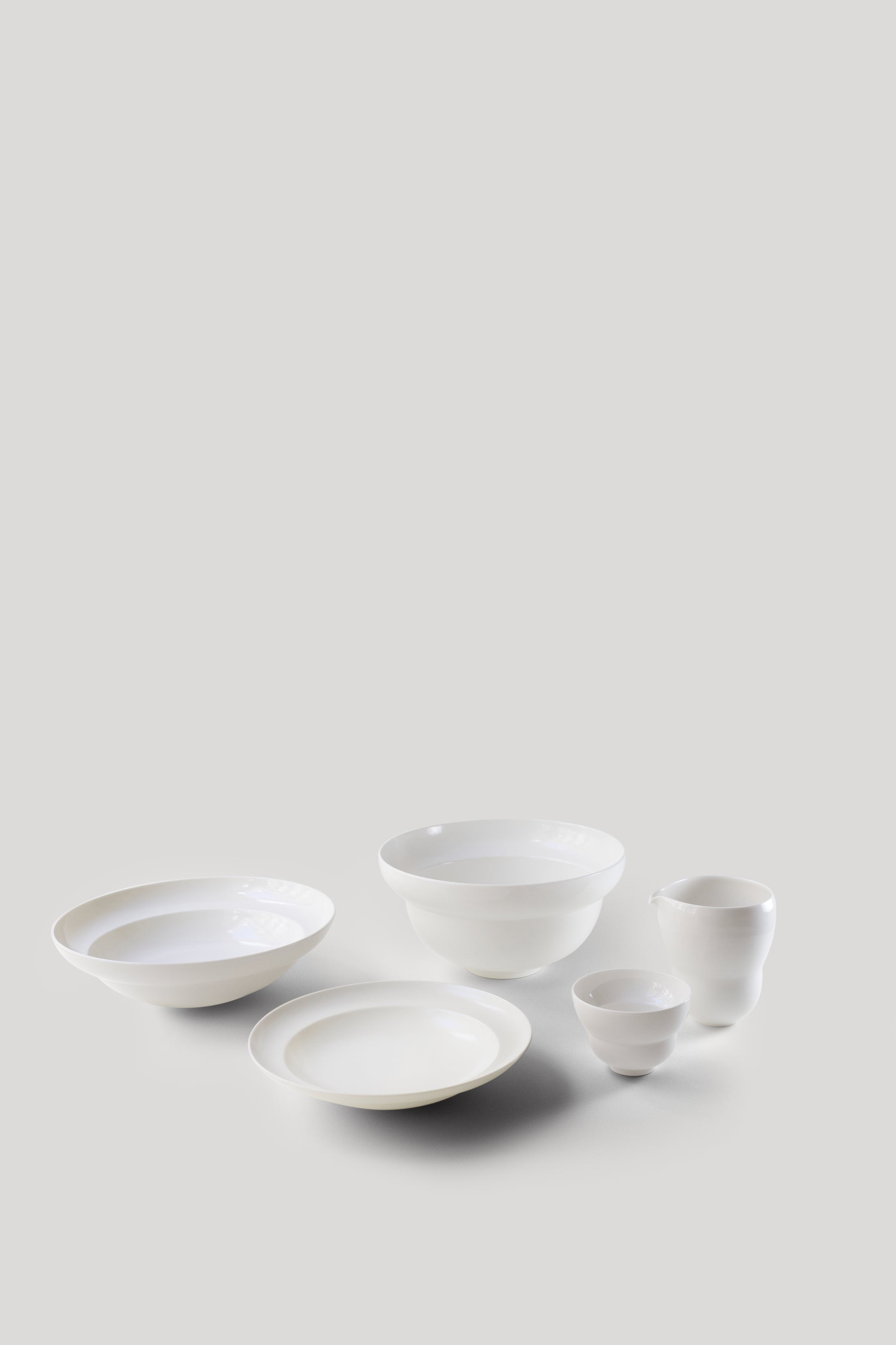 Set of white ceramic bowls on a light gray background