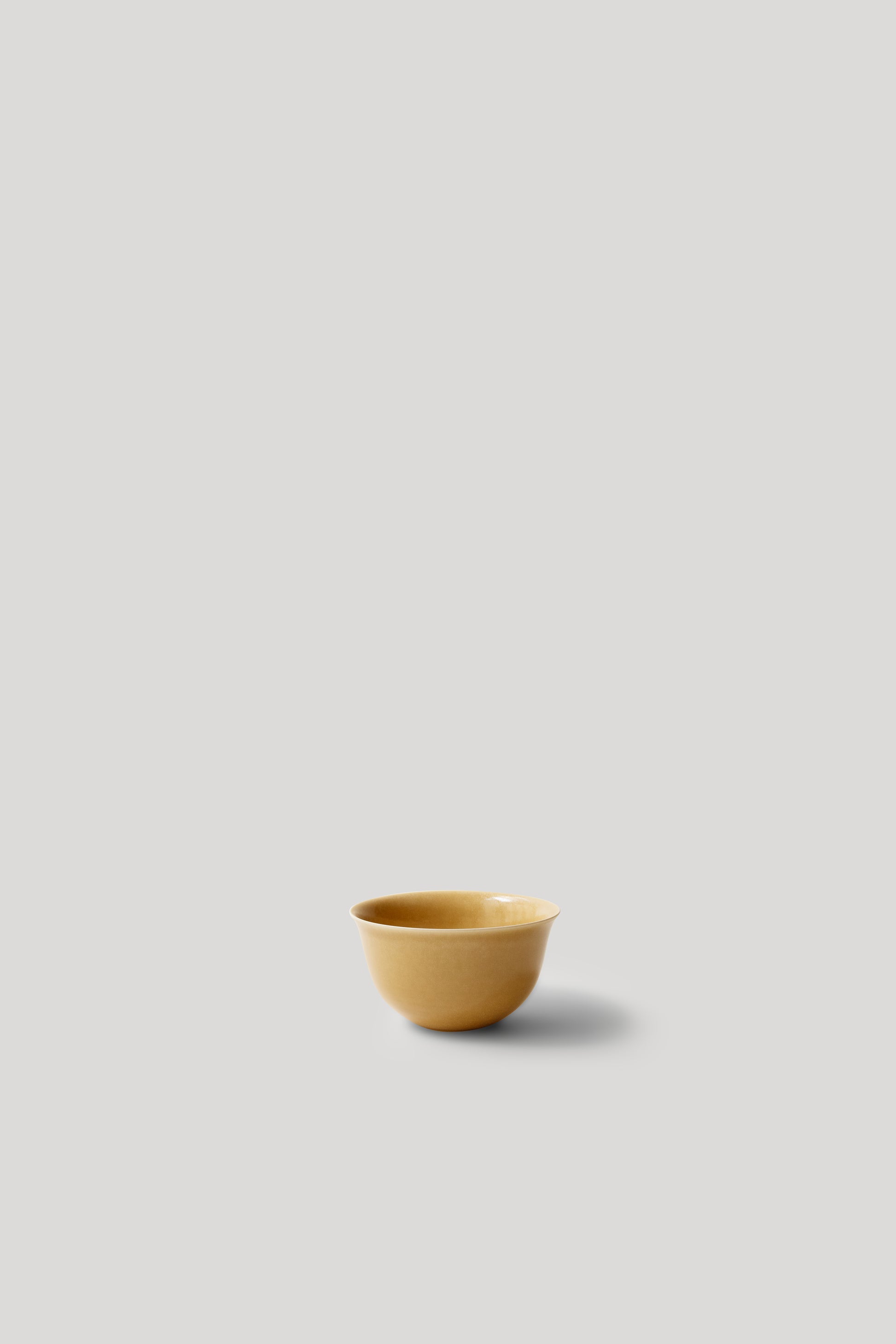 Yellow ceramic cup on a light gray background