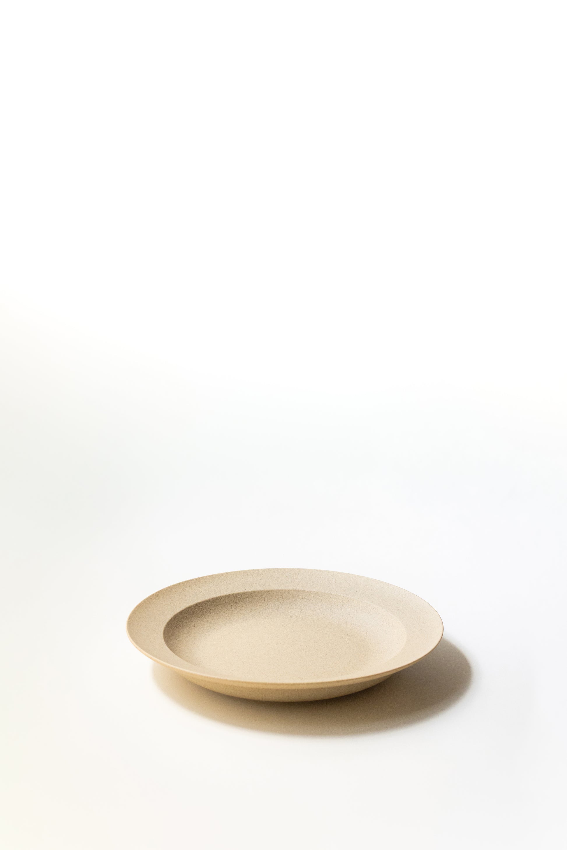Beige ceramic plate on a white background