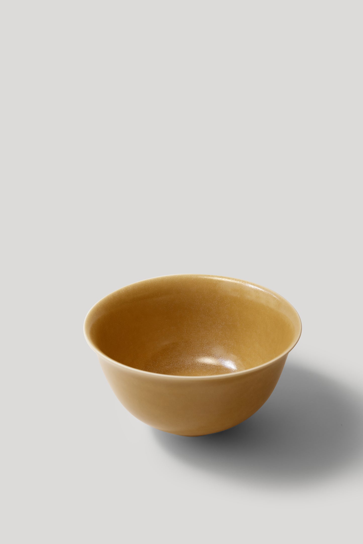 Yellow ceramic bowl on a light gray background