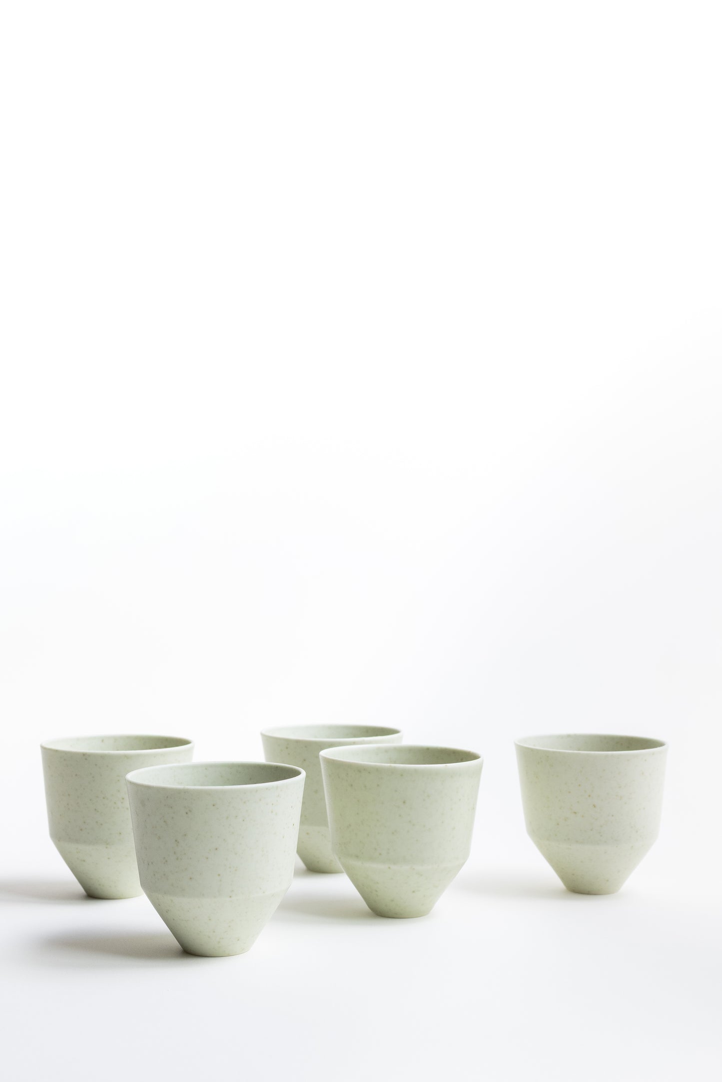 Set of six ceramic cups on a white background