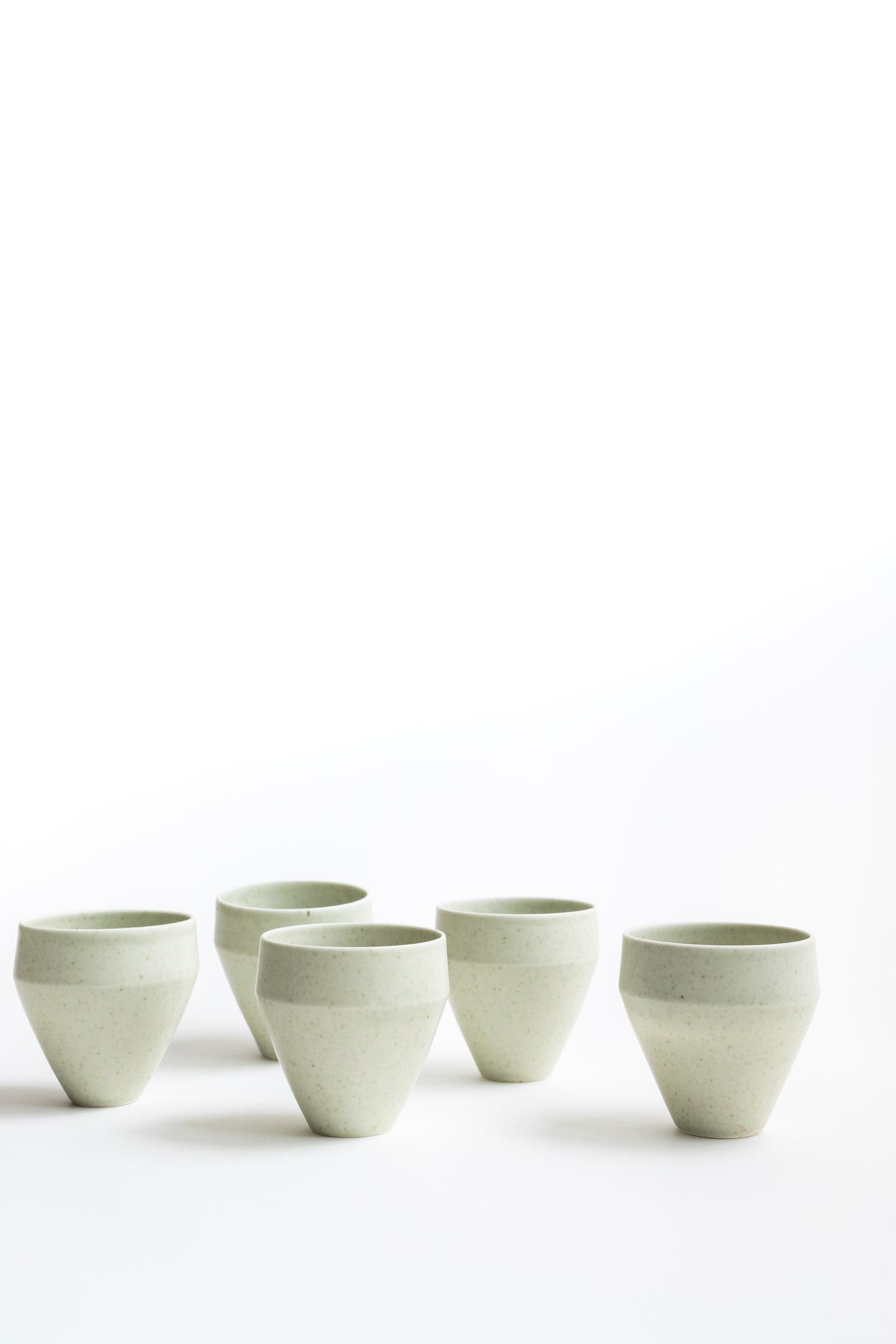 Set of five ceramic cups on a white background