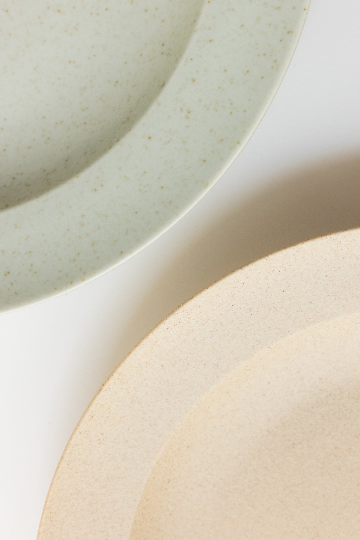 Close-up of ceramic plates with a neutral color palette on a light background