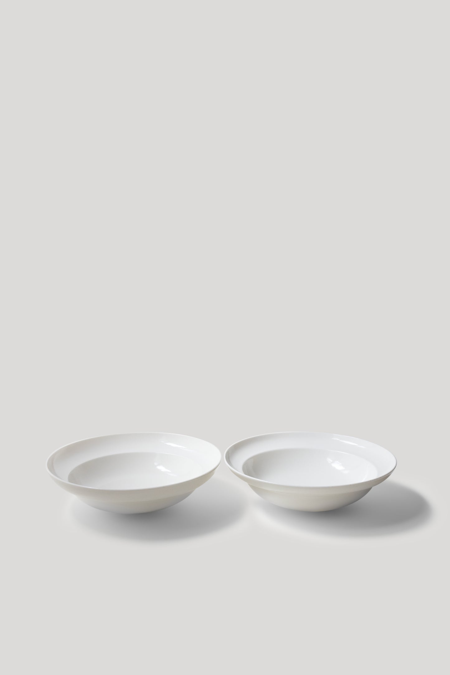 Two white ceramic bowls on a light gray background