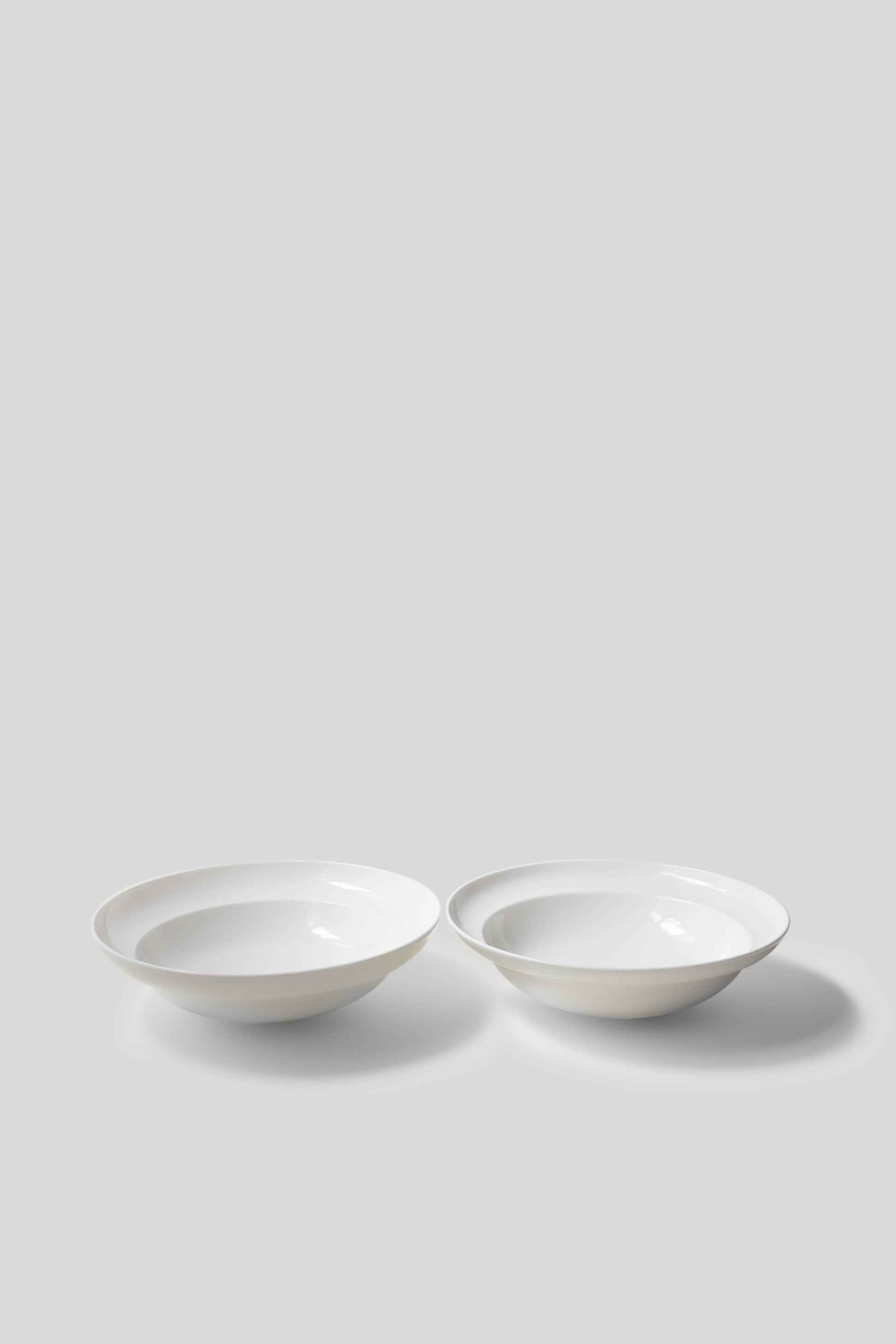 Two white ceramic bowls on a light gray background