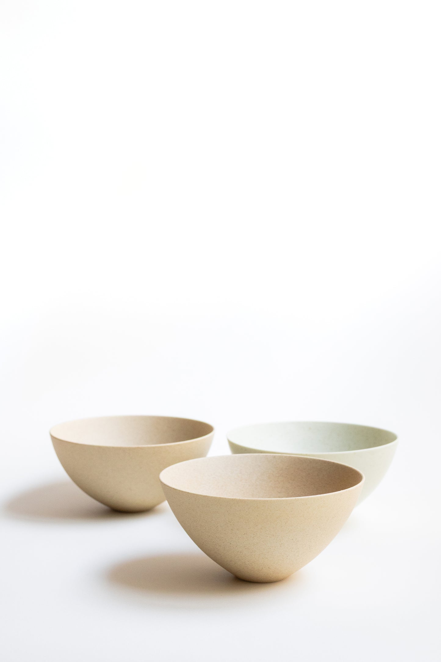 Three ceramic bowls of different sizes on a white background