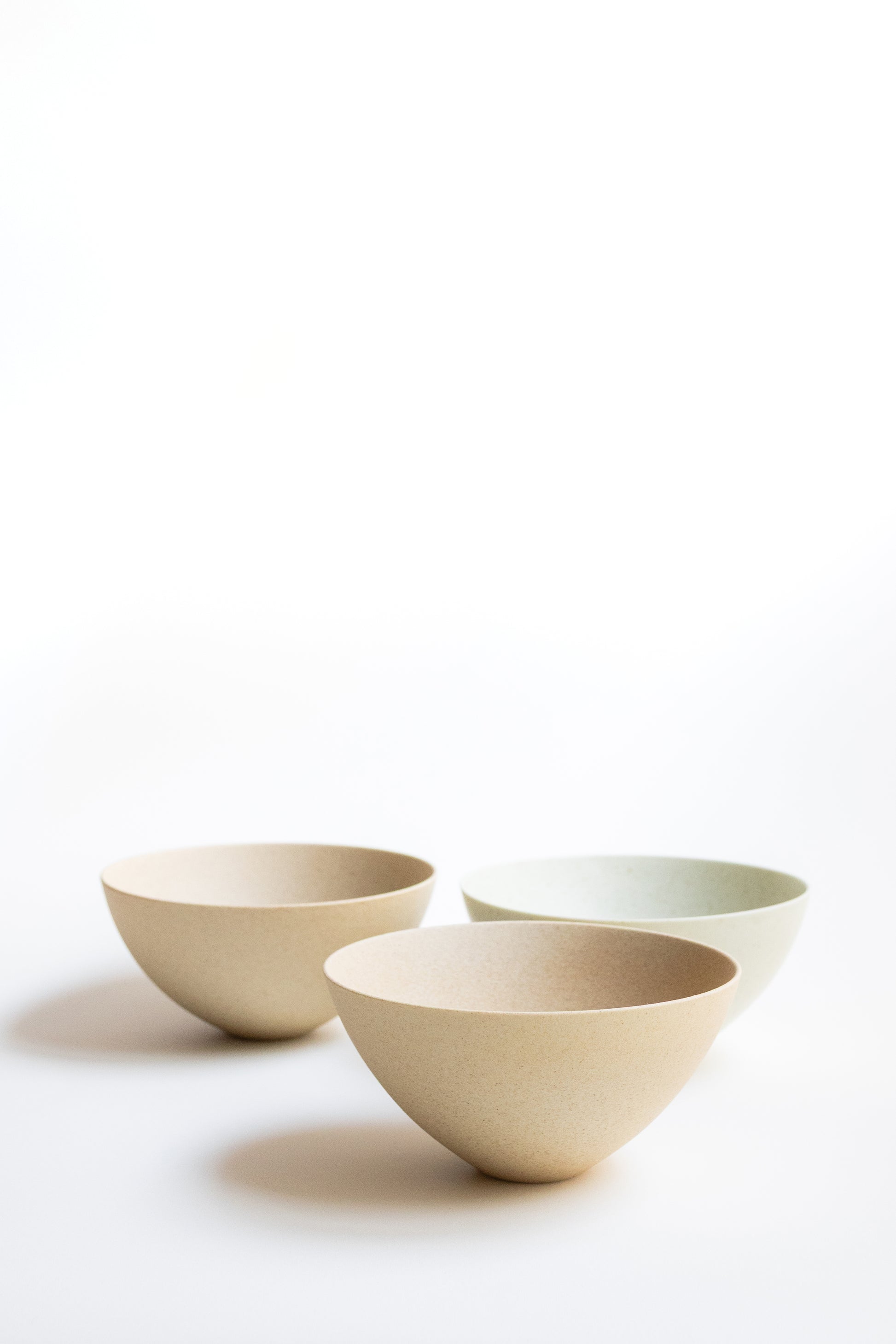 Three ceramic bowls of different sizes on a white background