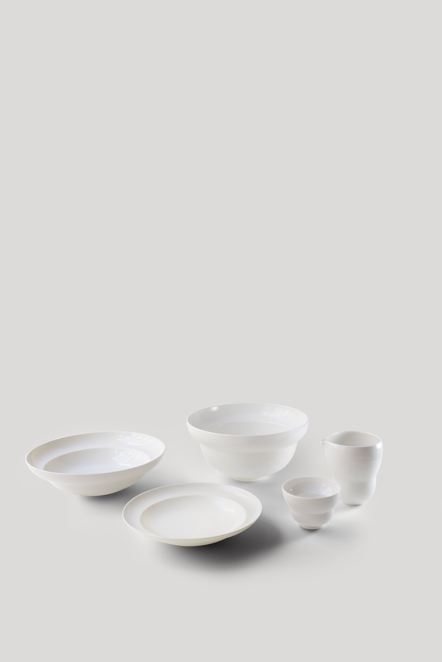 Set of white ceramic bowls on a light gray background