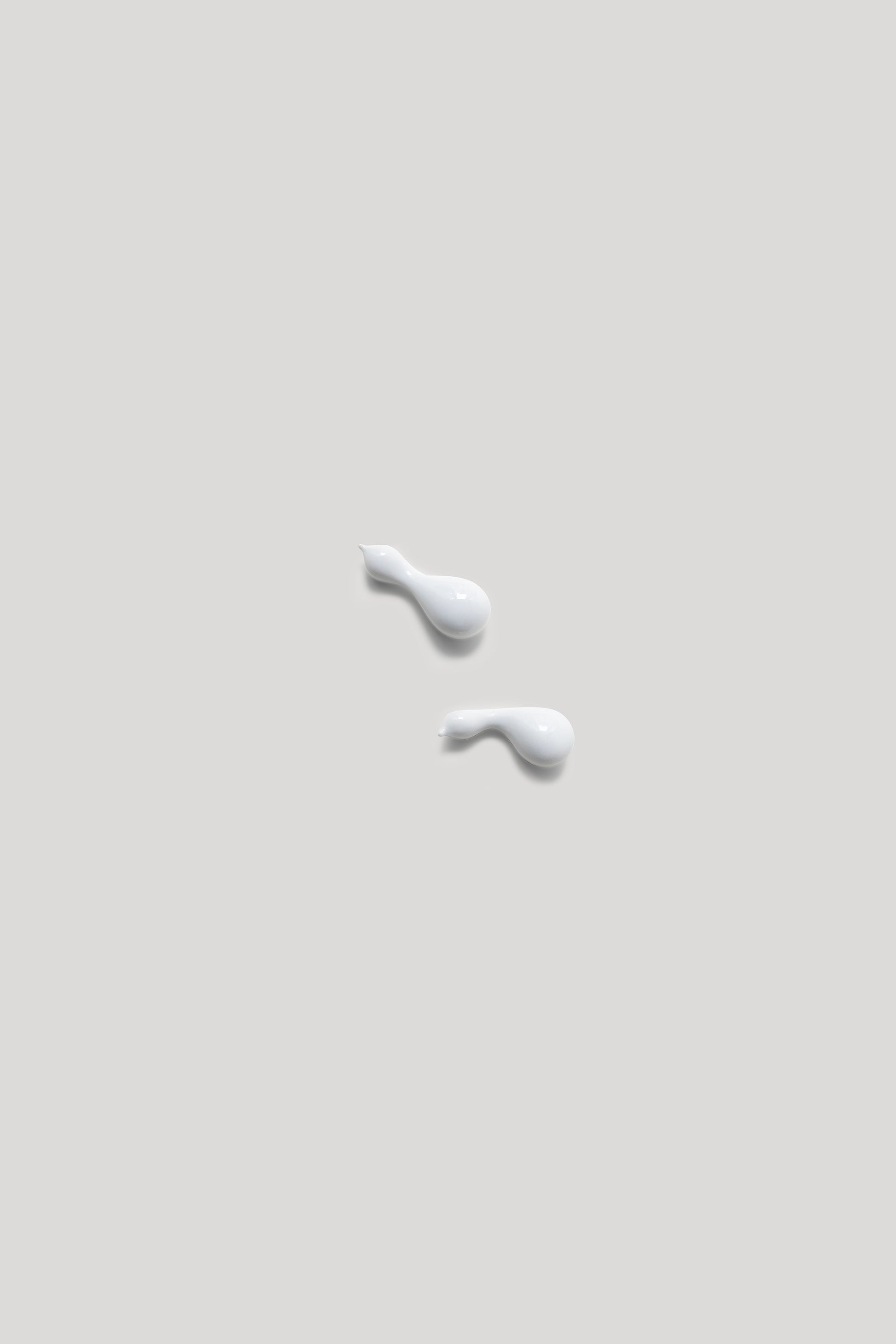 Two white droplets on a light gray background